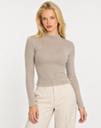 Maglia donna beige a costine con collo alto e punti luce indossata da Polly 7, vista a tre quarti