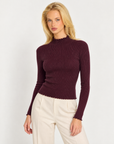 Maglia donna bordeaux a costine con collo alto e punti luce indossata da Polly 7, vista a tre quarti