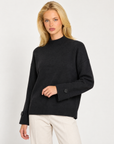 Maglia donna collo alto nero con bottoni sui polsini indossata da Polly 7, vista a tre quarti