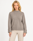 Maglia donna collo alto taupe con bottoni sui polsini indossata da Polly 7, vista frontale