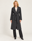Cappotto donna nero con cintura e ampi revers, indossato da Polly 7 - vista intera