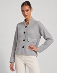 Cardigan donna corto grigio con collo alto, bottoni e tasche, indossato da Polly 6 – tre-quarti