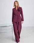 Completo blazer con fiore bordeaux indossato da Polly 5, cintura in vita, vista tre-quarti