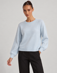 Maglia girocollo azzurro indossata da Polly 6, vista a tre quarti
