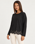 Maglia nero luminosa con bordo in pizzo, indossata da Polly 4, vista di tre quarti