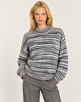 Maglia donna grigio a righe sfumate con collo alto indossata da Polly 7 - vista a tre quarti