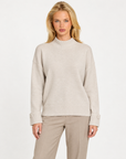 Maglia donna collo alto beige con bottoni sui polsini indossata da Polly 7, vista frontale