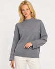 Maglia donna collo alto grigio con bottoni sui polsini indossata da Polly 7, vista a tre quarti