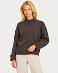 Maglia donna collo alto marrone con bottoni sui polsini indossata da Polly 7, vista a tre quarti