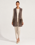 Gilet lungo con tasche in ecopelliccia marrone indossato da modella, vista frontale