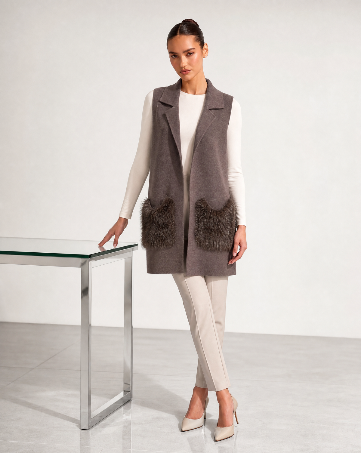 Gilet lungo con tasche in ecopelliccia marrone indossato da modella, vista tre quarti
