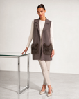 Gilet lungo con tasche in ecopelliccia marrone indossato da modella, vista tre quarti
