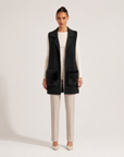 Gilet lungo con tasche in ecopelliccia nero indossato da modella, vista frontale