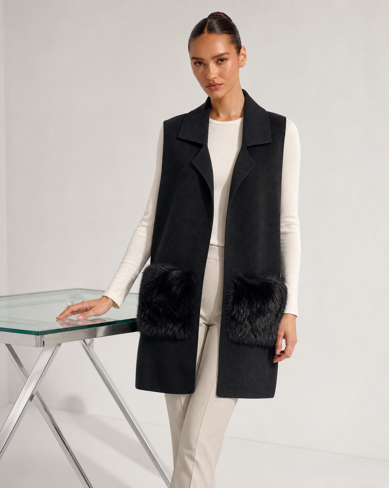Gilet lungo con tasche in ecopelliccia nero indossato da modella, vista tre quarti