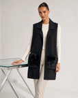 Gilet lungo con tasche in ecopelliccia nero indossato da modella, vista tre quarti