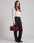 Borsa baguette bordeaux in vera pelle scamosciata intrecciata indossata da Polly2