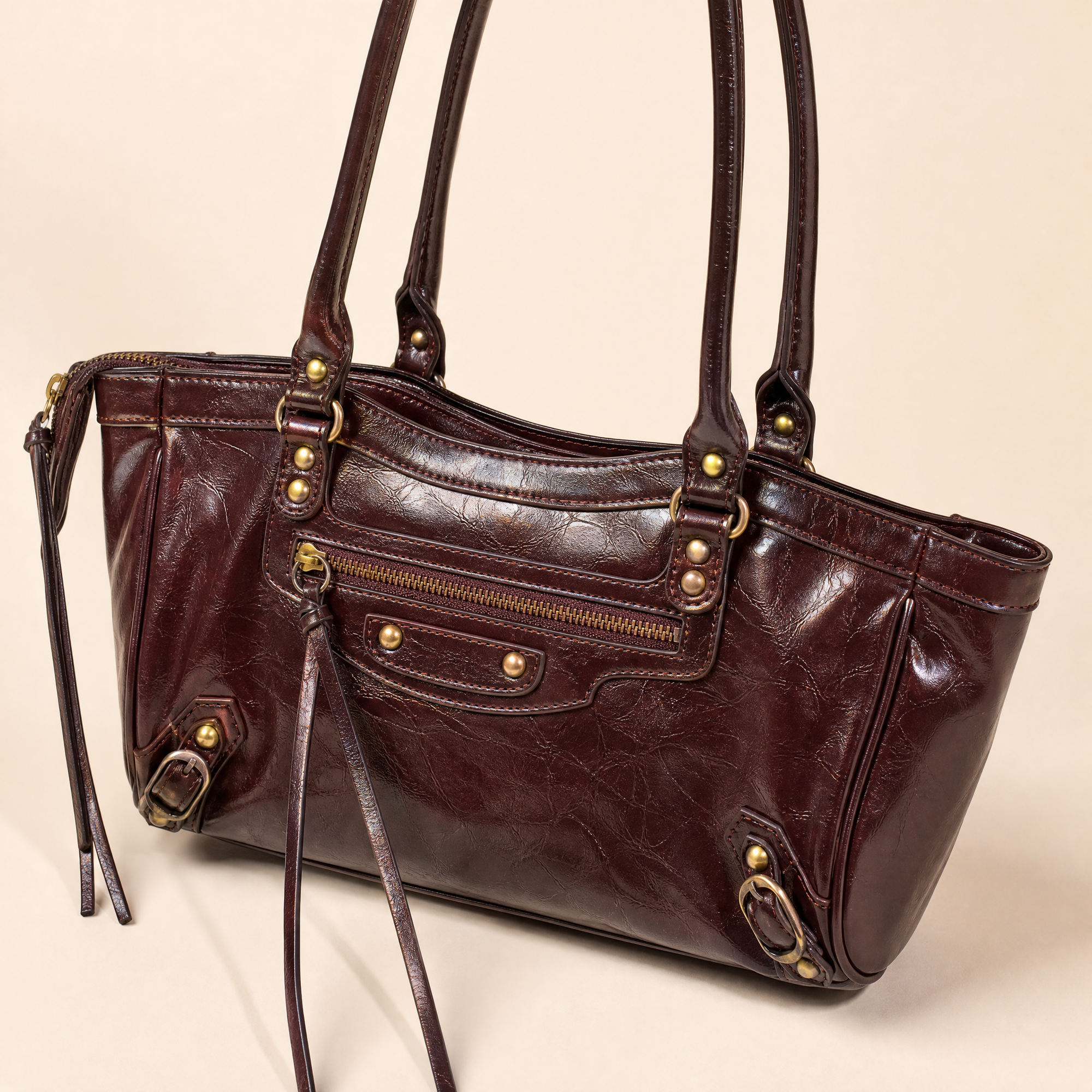 Dettaglio borsa in ecopelle bordeaux con zip e finiture color ottone