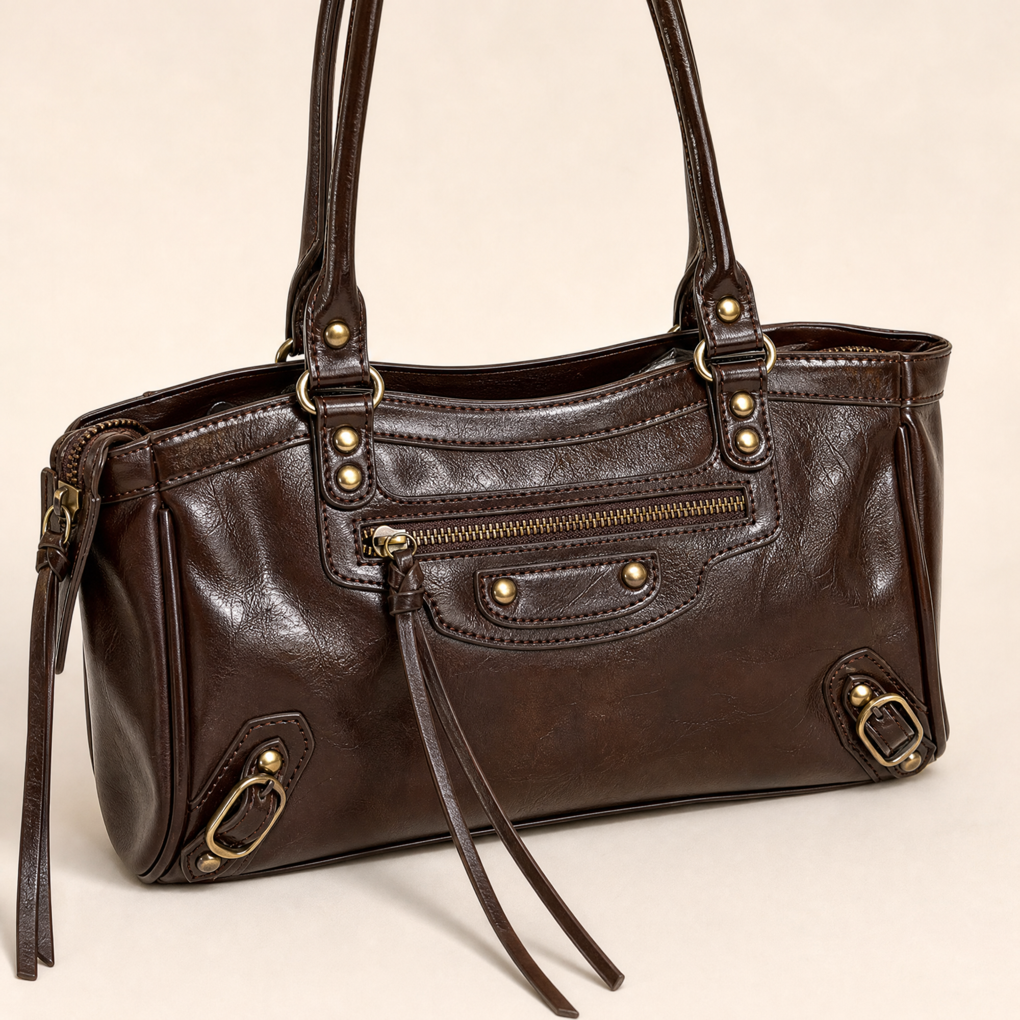 Dettaglio borsa in ecopelle marrone con zip e finiture color ottone