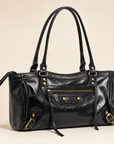 Dettaglio borsa in ecopelle nera con zip e finiture color ottone