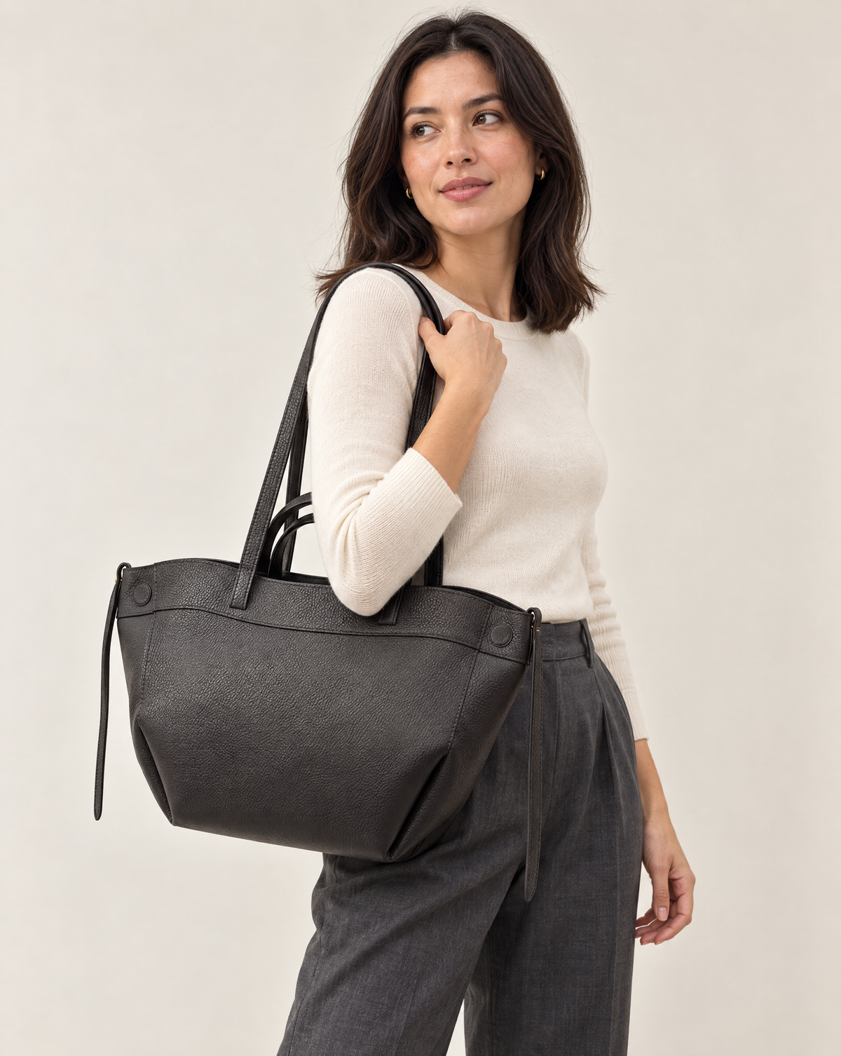Borsa shopper nera in vera pelle con doppi manici indossata a spalla