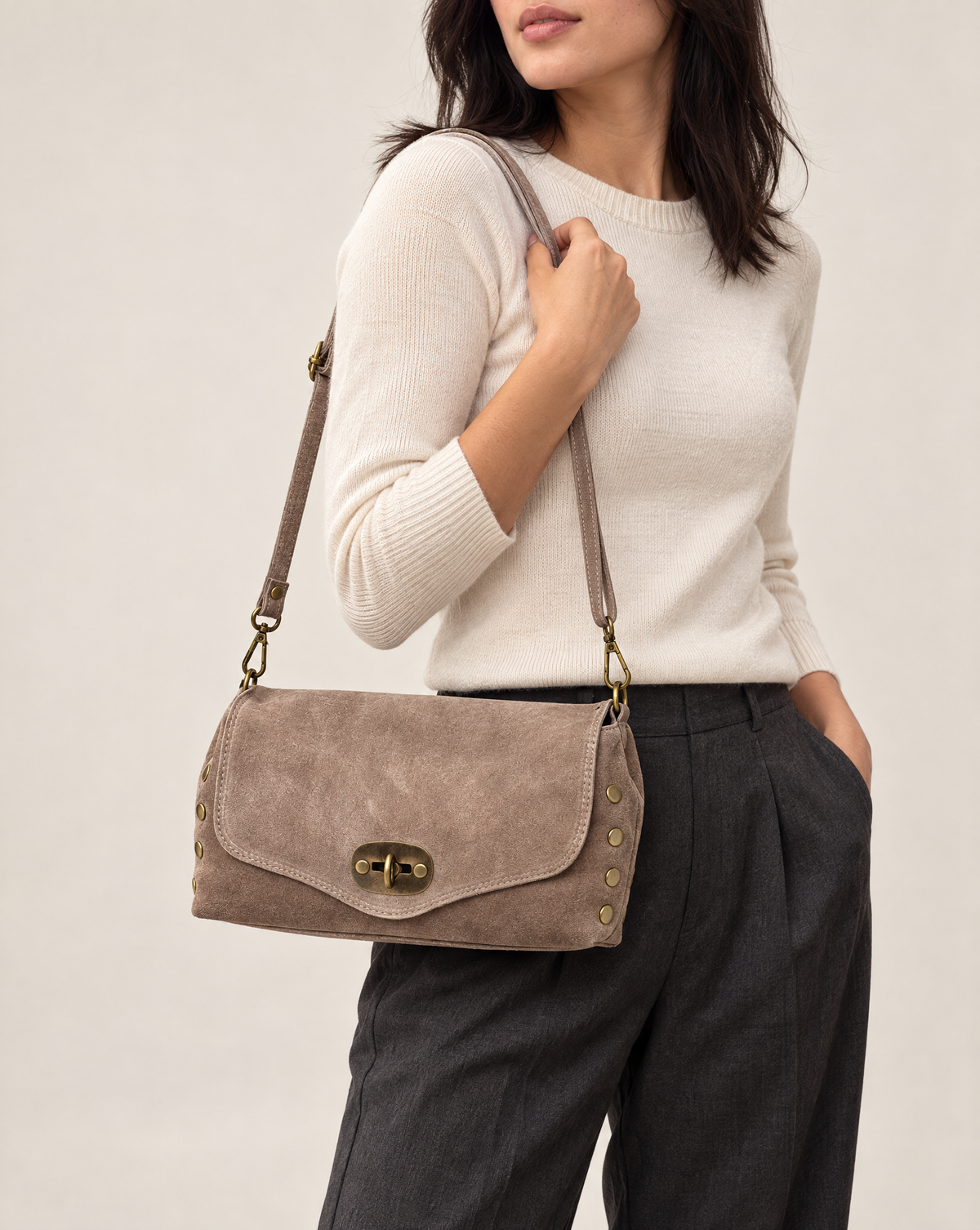 Borsa a tracolla in vera pelle scamosciata con borchie taupe indossata a spalla