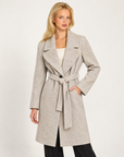 Cappotto donna beige con cintura e ampi revers, indossato da Polly 7 - vista a tre quarti
