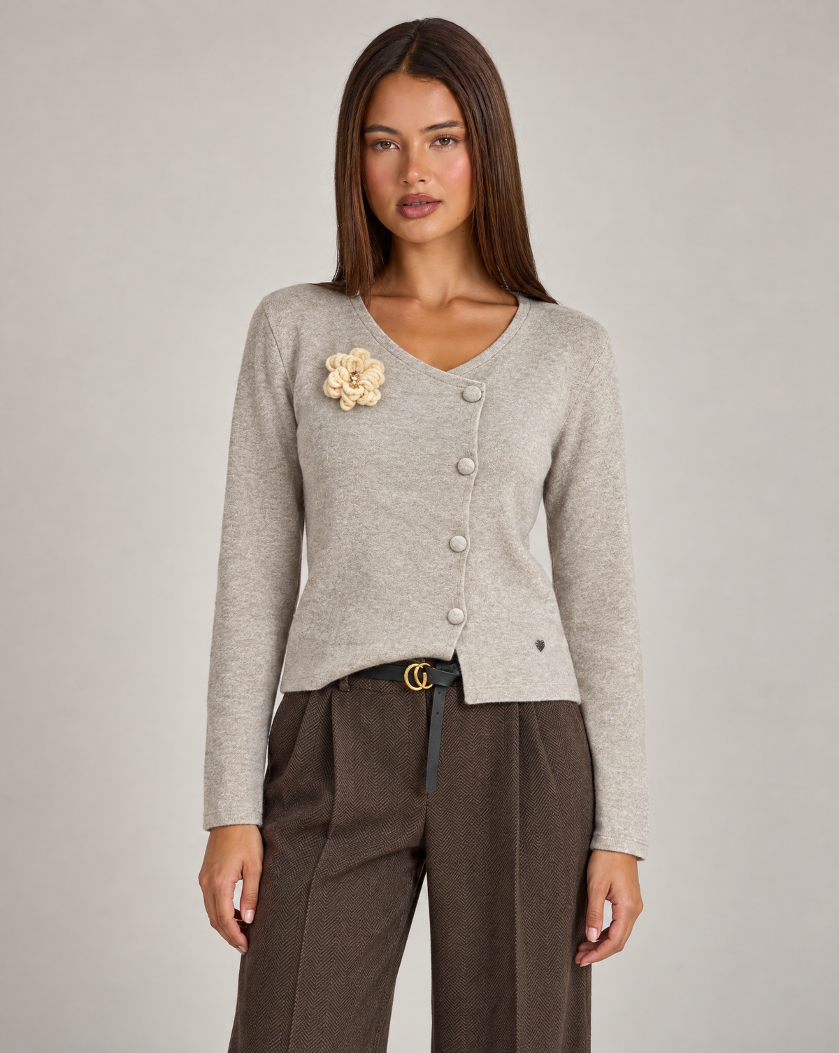 Cardigan donna beige con fiore e bottoni asimmetrici, indossato da Polly 4 con pantaloni spigati – vista frontale