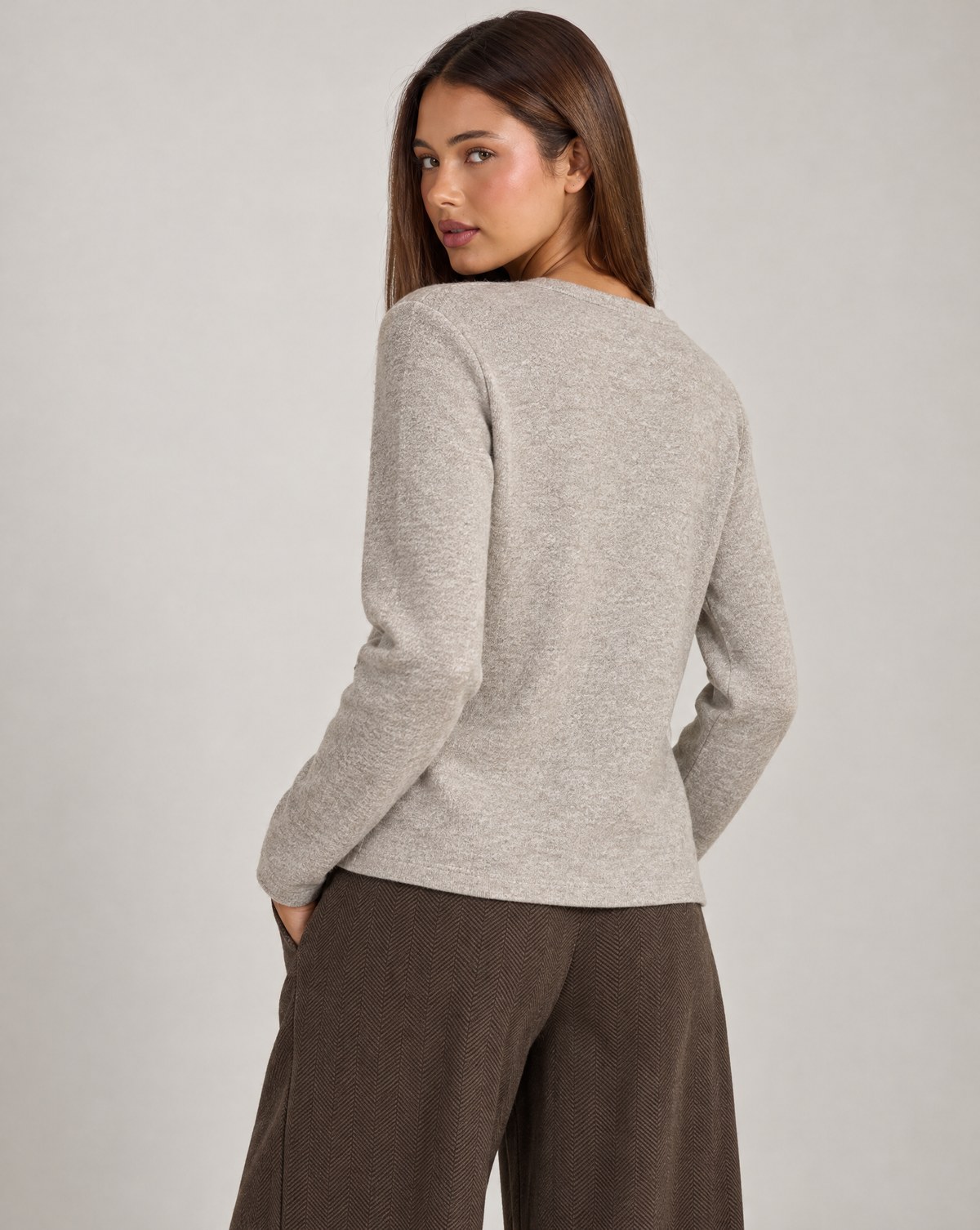 Cardigan donna beige con fiore e bottoni asimmetrici, indossato da Polly 4 con pantaloni spigati – vista posteriore