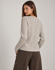 Cardigan donna beige con fiore e bottoni asimmetrici, indossato da Polly 4 con pantaloni spigati – vista posteriore
