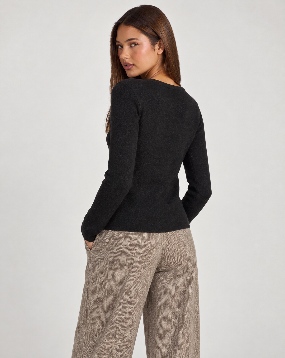 Cardigan donna nero con fiore e bottoni asimmetrici, indossato da Polly 4 con pantaloni spigati – vista posteriore