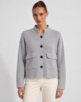 Cardigan donna corto grigio con collo alto, bottoni e tasche, indossato da Polly 6 – frontale