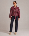 Giacca corta effetto pelle bordeaux con cintura indossata da Polly 6
