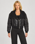 Giacca donna nera con collo teddy e inserti effetto pelle indossata da Polly 7 — vista frontale
