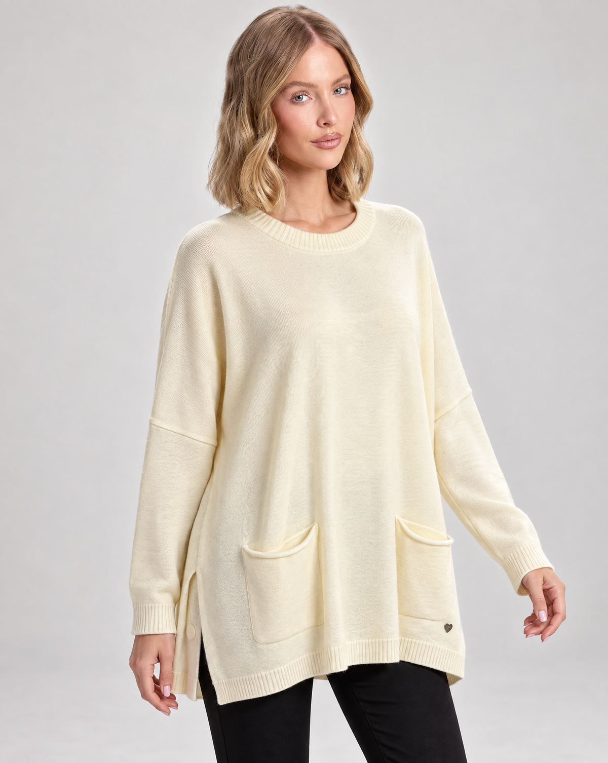 Maglia lunga con tasche frontali panna indossata da Polly 5, vista tre quarti