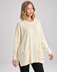 Maglia lunga con tasche frontali panna indossata da Polly 5, vista tre quarti