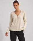 Maglia cardigan scollo a V beige indossata da Polly 6, vista a tre quarti