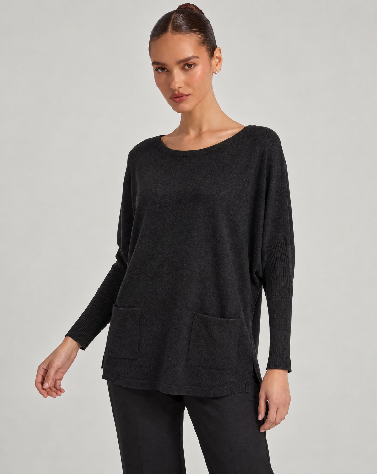 Maglia donna ampia con tasche nero indossata da Polly 6, vista a tre quarti