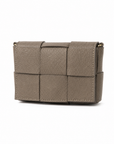 Mini bag intrecciata in vera pelle color taupe su sfondo bianco