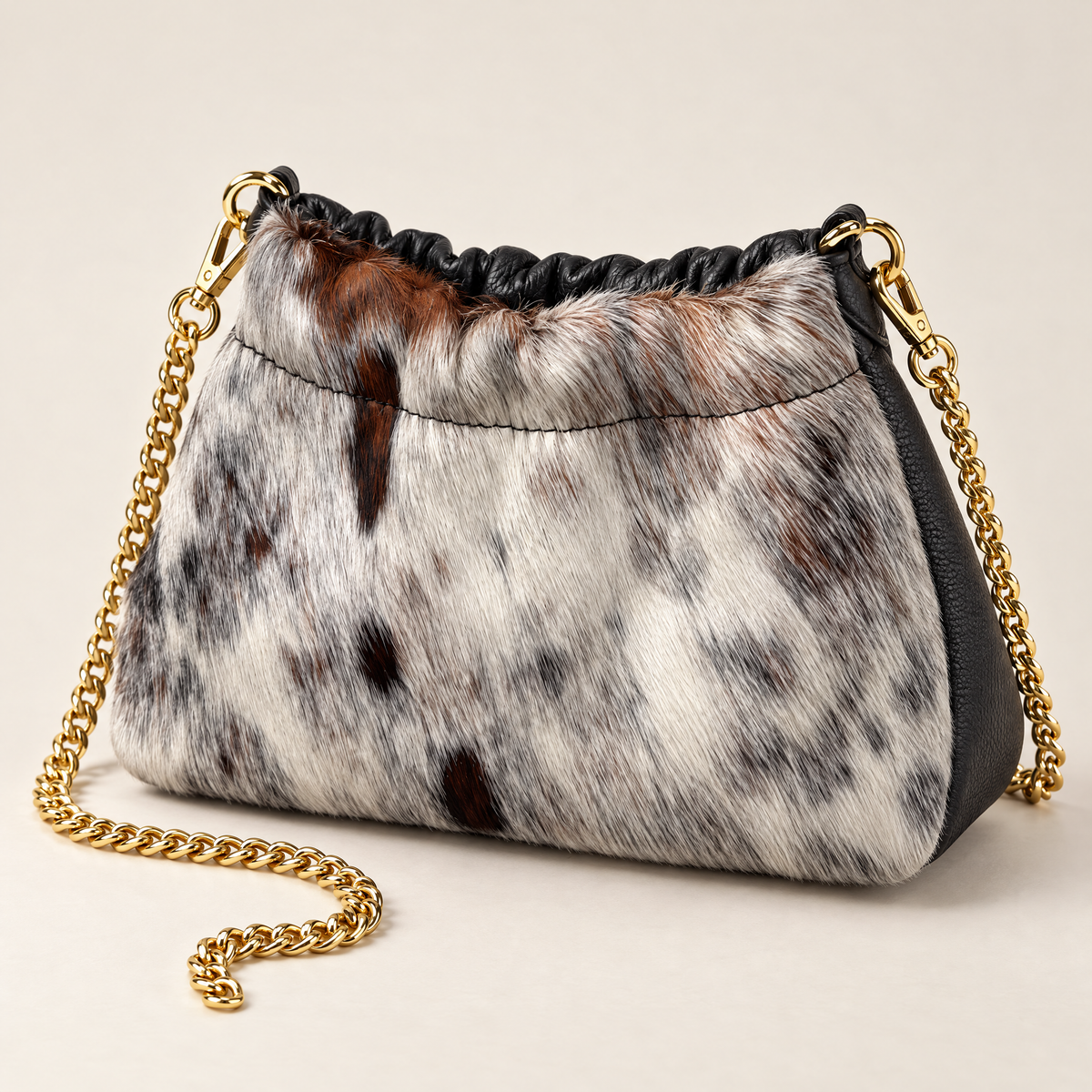 Mini borsa in vera pelle maculata con catena dorata, vista a tre quarti