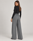 Pantaloni donna a palazzo spigati grigio con cintura, indossati da Polly 4 – vista posteriore